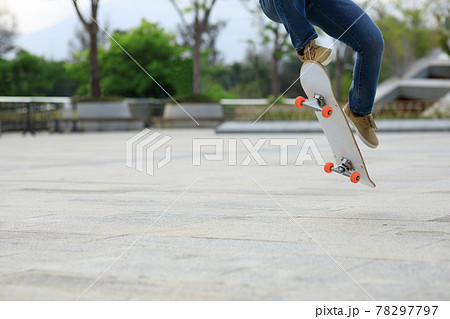 Asian woman skateboarder skateboarding in modern city 78297797