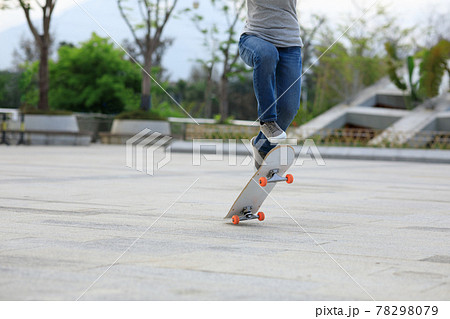 Asian woman skateboarder skateboarding in modern city 78298079
