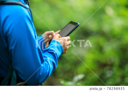 Woman hiker using smartphone in spring forest Woman hiker using smartphone in spring forest 78298935