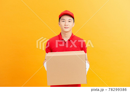 Smiling delivery man carrying a parcel box Smiling delivery man carrying a parcel box 78299386
