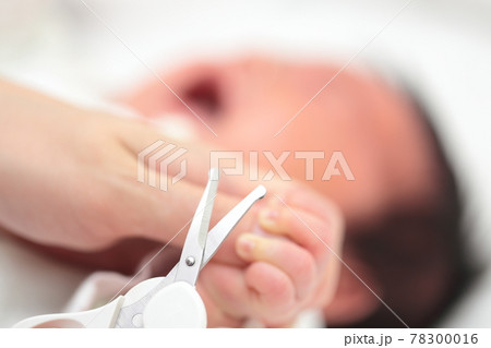 新生児の手の爪切りをするママ 78300016