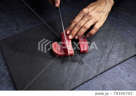 Female cook preparing a piece of bluefin tuna to make sushi. Asian food concept 78300705