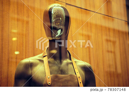 Stylish black mannequin in an apron on a store window. 78307148