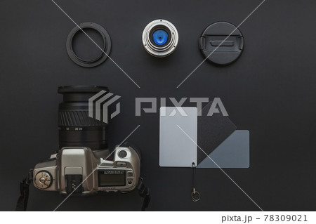 Photographer workplace with dslr camera system, camera cleaning kit, lens and camera accessory on dark black table background. Hobby travel photography concept Flat lay top view copy space 78309021