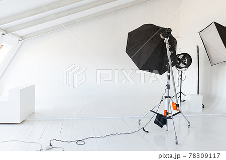 Empty photo studio with lighting equipment. Photographer workplace interior with professional tool set gear. Flash light white background scenes ready for studio shooting. Modern photographer studio 78309117