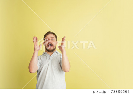 Half-length portrait of young Caucasian man isolated on light yellow background. Half-length portrait of young Caucasian man isolated on light yellow background. 78309562