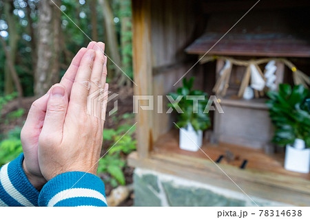 山道に設置された祠に手を合わせる男性の写真 78314638