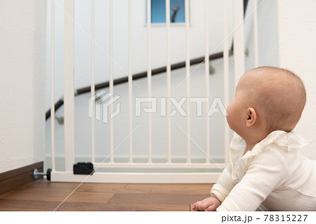 ベビーゲートの前にいる赤ちゃん 78315227