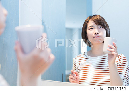 鏡の前でうがいをする若い女性 78315586