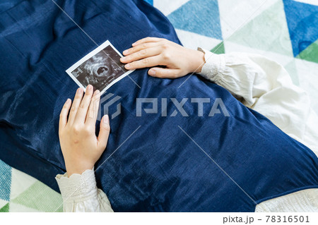 赤ちゃんのエコー写真を持った妊婦の写真。妊娠中のイメージ。 赤ちゃんのエコー写真を持った妊婦の写真。妊娠中のイメージ。 78316501