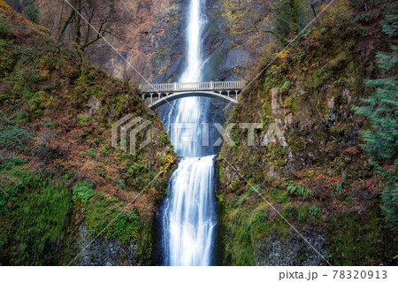 Bridge going over a river with Multnomah Falls 78320913