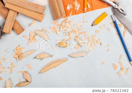 Handmade wooden fishing tacles graph paper background with tools and blanks. 78322162