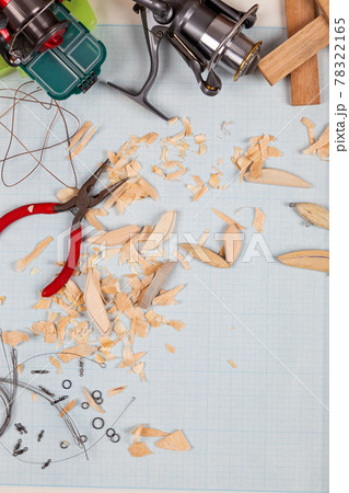 Handmade wooden fishing tacles graph paper background with tools and blanks. Handmade wooden fishing tacles graph paper background with tools and blanks. 78322165