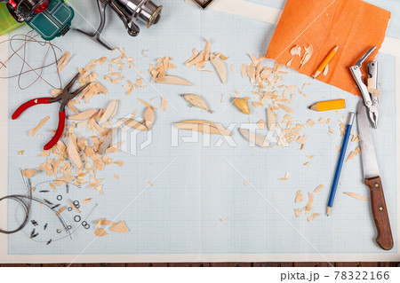 Handmade wooden fishing tacles graph paper background with tools and blanks. 78322166