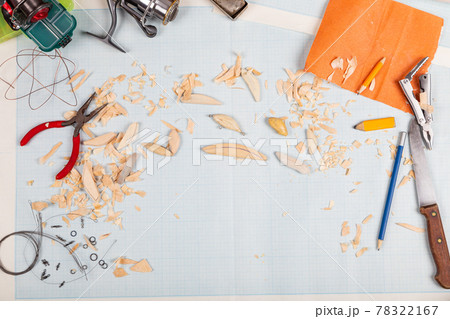 Handmade wooden fishing tacles graph paper background with tools and blanks. 78322167