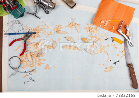 Handmade wooden fishing tacles graph paper background with tools and blanks. Handmade wooden fishing tacles graph paper background with tools and blanks. 78322168
