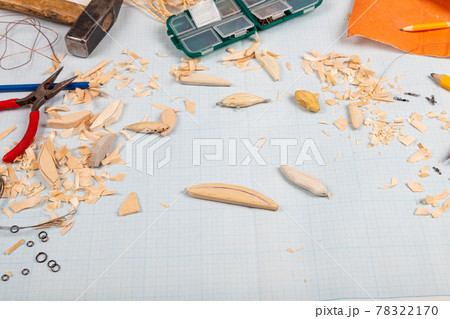 Handmade wooden fishing tacles graph paper background with tools and blanks. 78322170