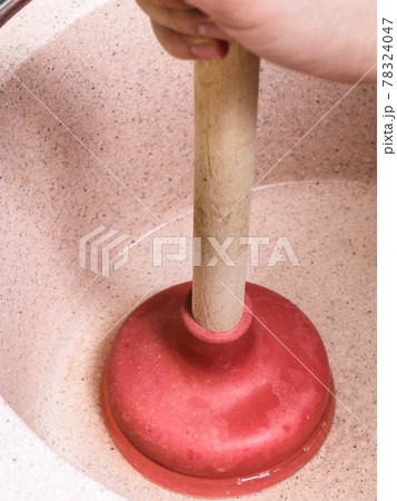 man clears water blockage in pink sink by plunger man clears water blockage in pink sink by plunger 78324047