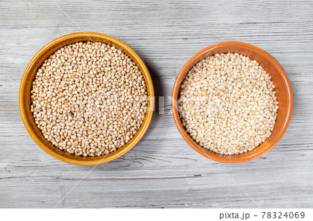 whole and polished sorghum seeds in bowls 78324069