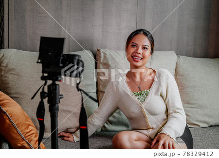 Asian blogger, podcaster or vlogger looking at camera and talking on video shooting with technology Asian blogger, podcaster or vlogger looking at camera and talking on video shooting with technology 78329412