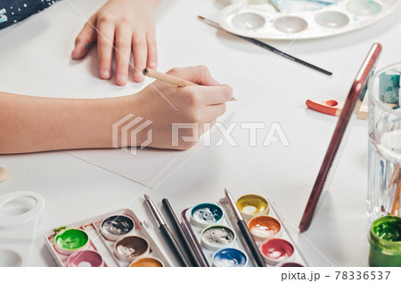 The hands of a cute caucasian girl are drawing a pencil sketch. A girl is watching an online lesson on a smartphone. Classes with children at home. Hands in the frame The hands of a cute caucasian girl are drawing a pencil sketch. A girl is watching an online lesson on a smartphone. Classes with children at home. Hands in the frame 78336537
