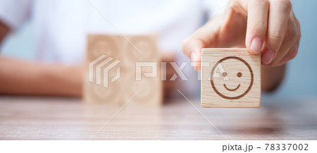 Man hand holding emotion face block. Customer choose Emoticon for user reviews. Service rating, ranking, customer review, satisfaction, evaluation and feedback concept 78337002