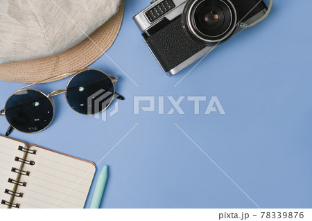 Camera, sunglasses, notebook and hat on blue background. Camera, sunglasses, notebook and hat on blue background. 78339876
