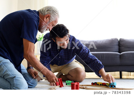 Happiness father and son having fun with childhood toys at home. Happiness father and son having fun with childhood toys at home. 78343398