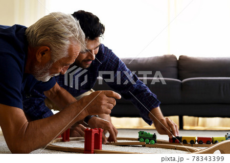 Happiness father and son having fun with childhood toys at home. Happiness father and son having fun with childhood toys at home. 78343399