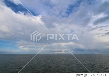 Rainbow above the north sea against a blue sky with clouds Rainbow above the north sea against a blue sky with clouds 78343451