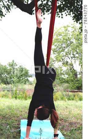 The girl is engaged in fly yoga in nature. Hammock suspended from a tree. Relax meditation The girl is engaged in fly yoga in nature. Hammock suspended from a tree. Relax meditation 78343770