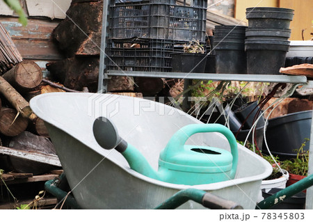 Gardening equipment: cart, watering can, crates, fertilizers and flowers Gardening equipment: cart, watering can, crates, fertilizers and flowers 78345803