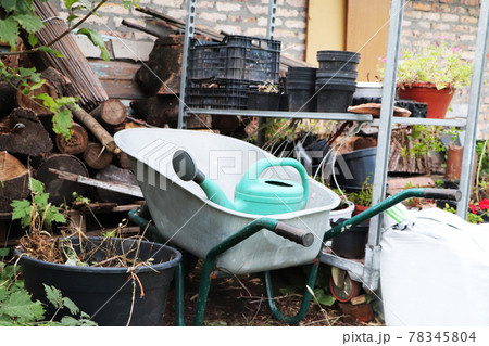 Gardening equipment: cart, watering can, crates, fertilizers and flowers Gardening equipment: cart, watering can, crates, fertilizers and flowers 78345804