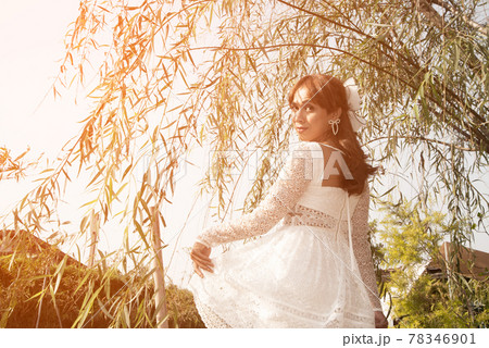 Pretty Asian woman posing relax under the tree on the canal in the park. 78346901