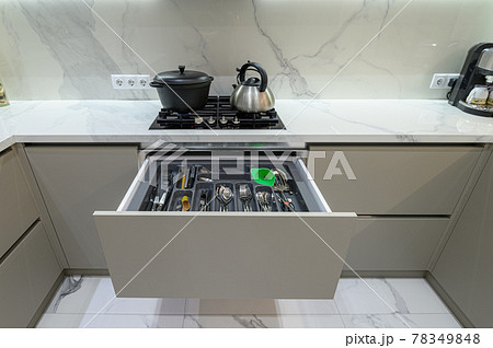 Open drawer with cutlery at modern white woden kitchen in classic style Open drawer with cutlery at modern white woden kitchen in classic style 78349848