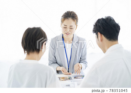 夫婦に不動産を営業するスーツ姿の女性 夫婦に不動産を営業するスーツ姿の女性 78351045