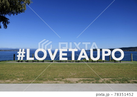 青い空と湖の前に立つ白い#LOVETAUPOのモニュメント【ニュージーランド・タウポ】 78351452