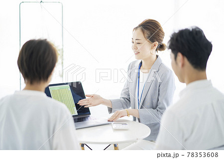夫婦に説明するスーツ姿の女性 夫婦に説明するスーツ姿の女性 78353608