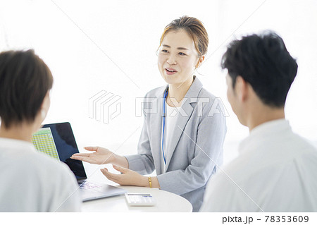 夫婦に説明するスーツ姿の女性 夫婦に説明するスーツ姿の女性 78353609
