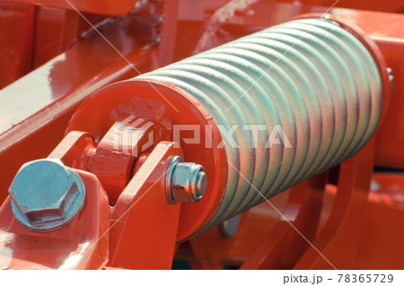 Big and hard steel silver spring as part and detail of red industrial or agricultural machine Big and hard steel silver spring as part and detail of red industrial or agricultural machine 78365729