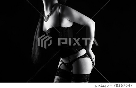 Black and white photo of the young woman in silk lingerie with arms on hips 78367647