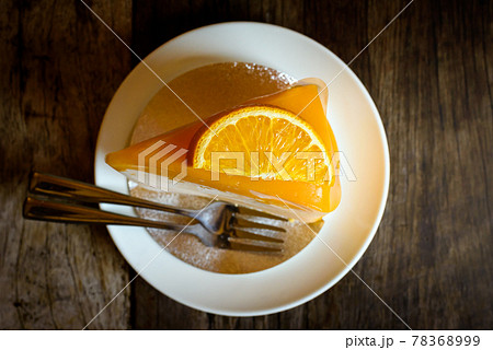 Orange cake with orange topping on wooden table 78368999