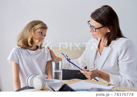 Girl child at session with female psychologist counselor social worker in office Girl child at session with female psychologist counselor social worker in office 78370778
