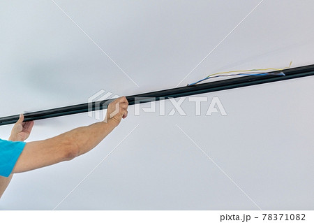 Installation of LED ceiling mounted modern track downlight. 78371082