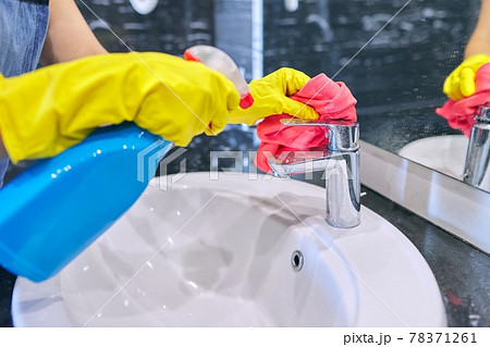 Close up of hands in gloves with detergent washing polishing washbasin, chrome sink Close up of hands in gloves with detergent washing polishing washbasin, chrome sink 78371261