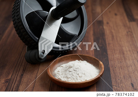 トレーニング用の粉末状のサプリメントと腹筋ローラー 78374102