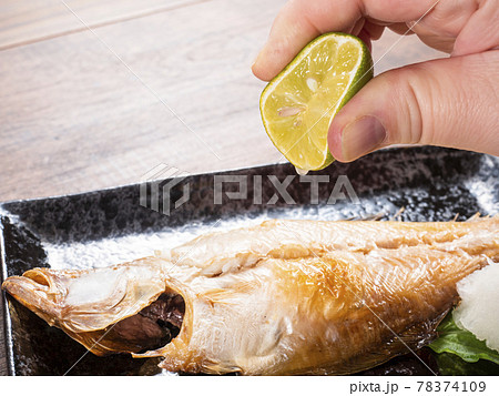 カレイの干物　焼き魚　スダチを搾る 78374109