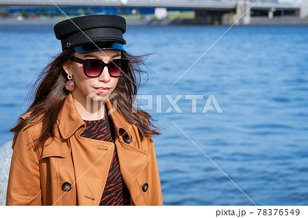 Portrait of woman on embankment on sunny spring day with newspaper in her hand Portrait of woman on embankment on sunny spring day with newspaper in her hand 78376549