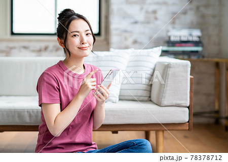 リビングでスマホを見る若い女性 78378712
