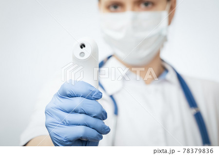Doctor pointing infrared thermometer gun to check body temperature epidemic virus outbreak concept Doctor pointing infrared thermometer gun to check body temperature epidemic virus outbreak concept 78379836